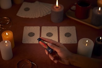 A person sitting at a table with cards and candles