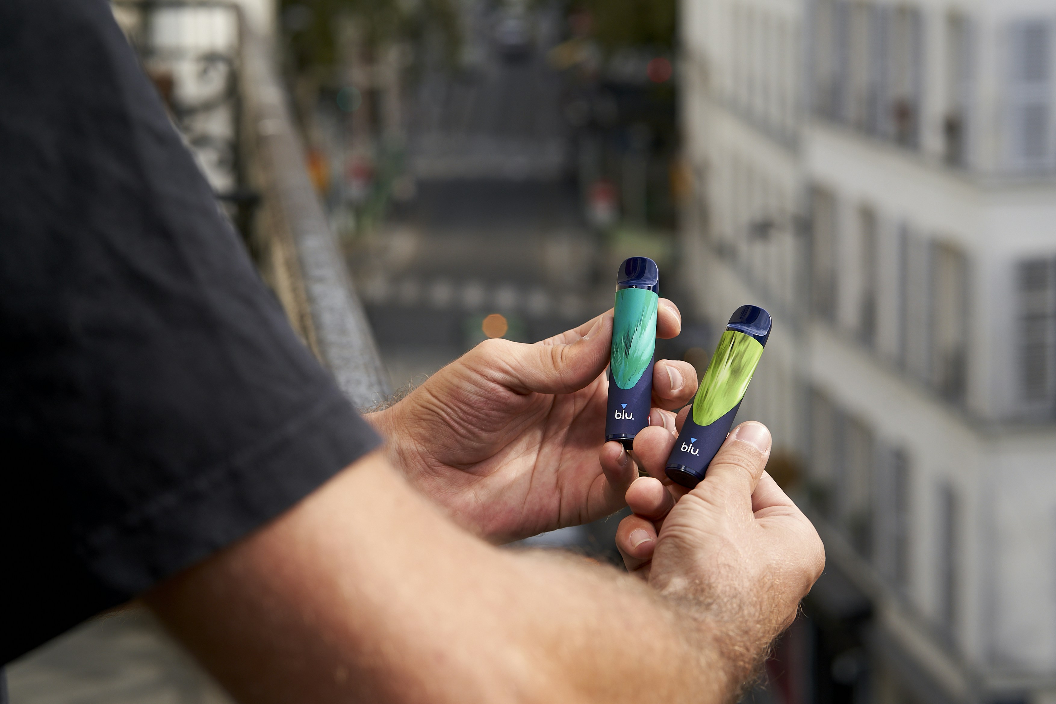 Um homem está segurando duas pequenas escovas de dentes na mão