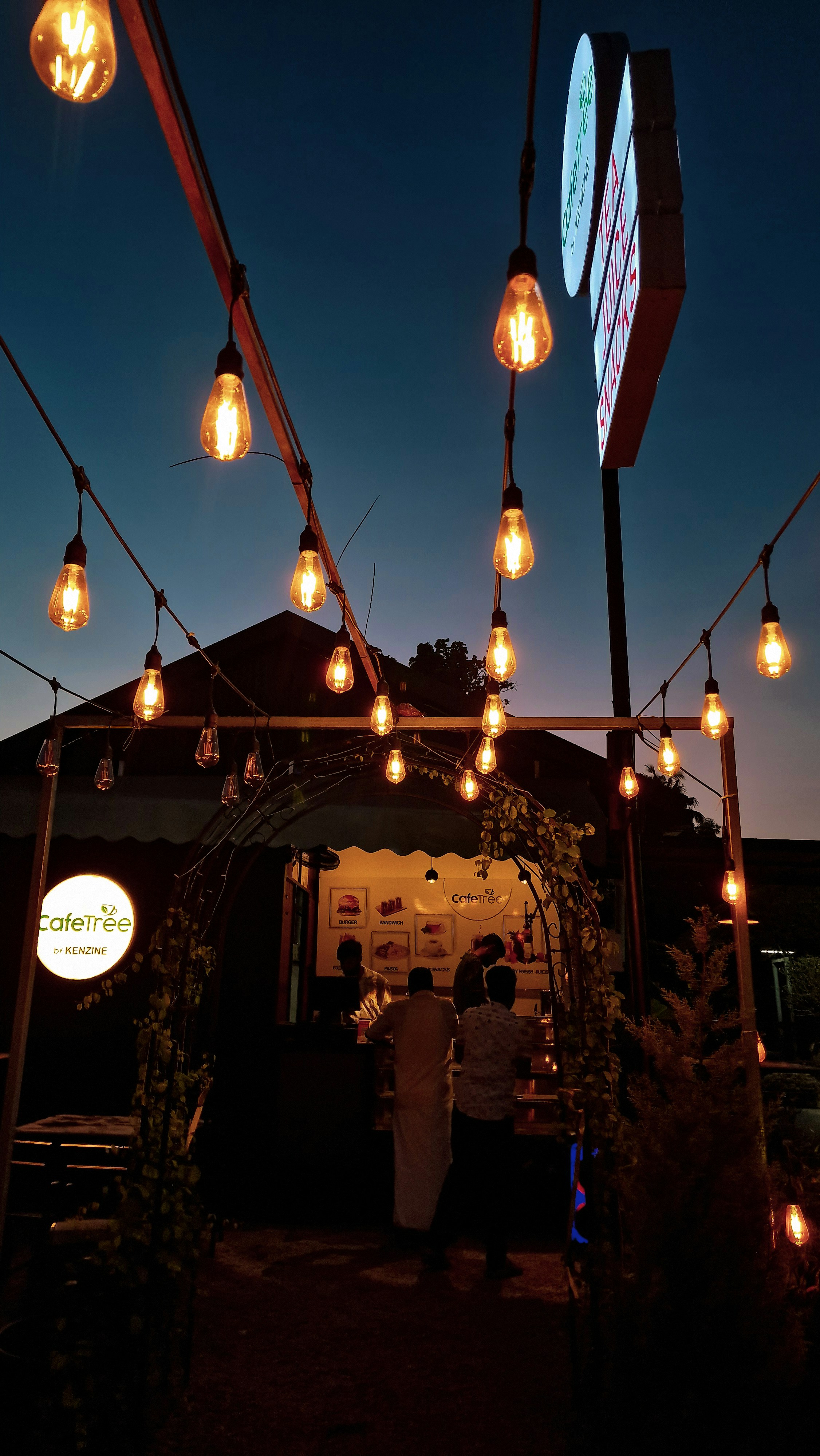 Cafe exterior at dusk with warm glowing lights and inviting entrance