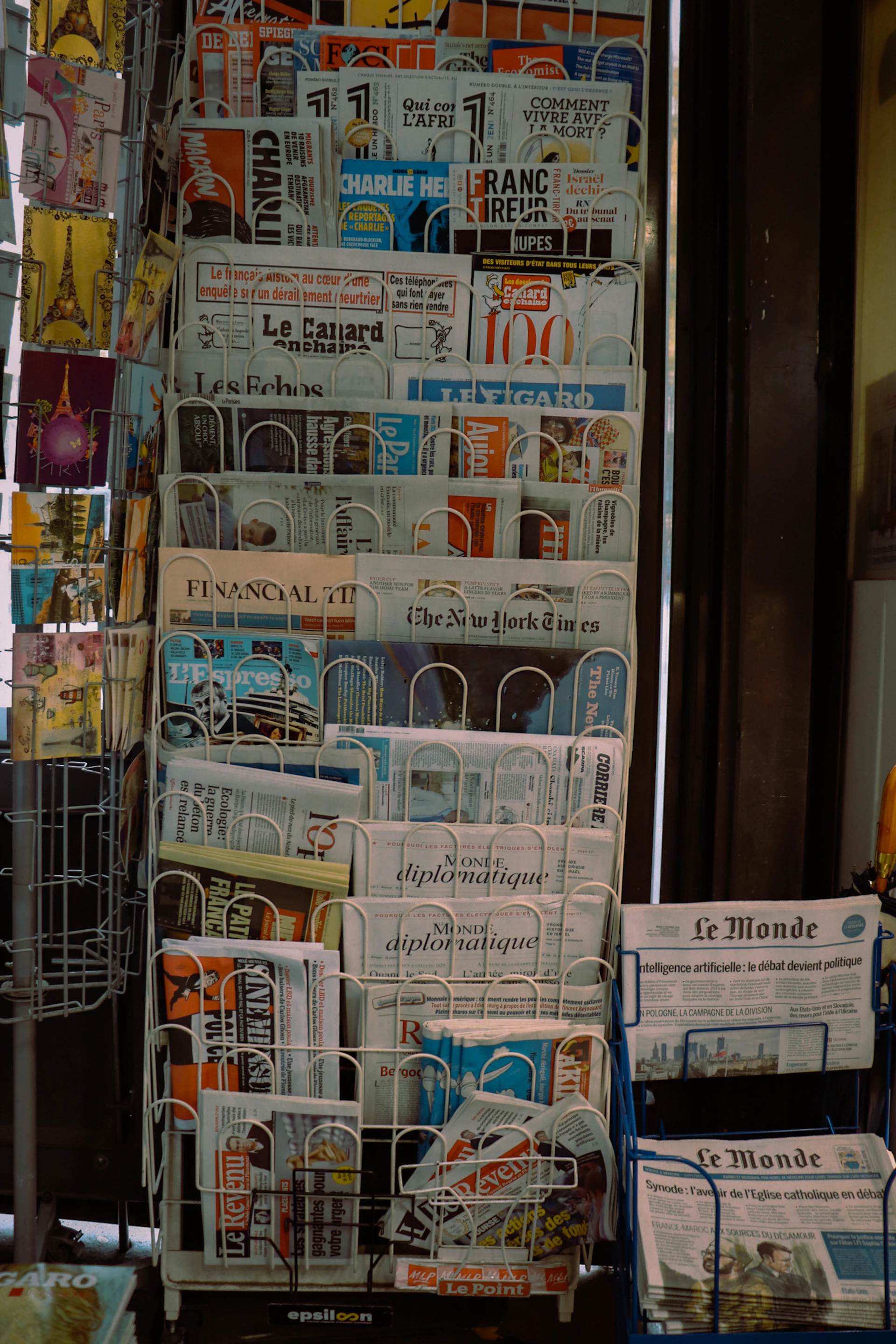 A stack of newspapers sitting on top of a blue cart