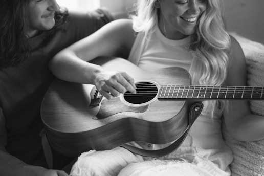 A woman sitting on a couch playing a guitar