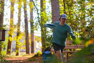 A man in a green shirt is throwing a frisbee