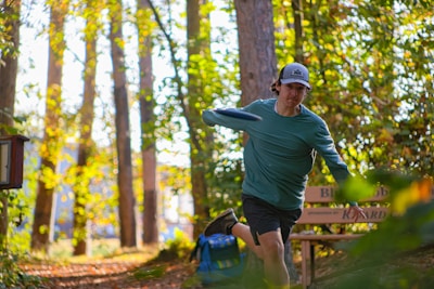 A man in a green shirt is throwing a frisbee