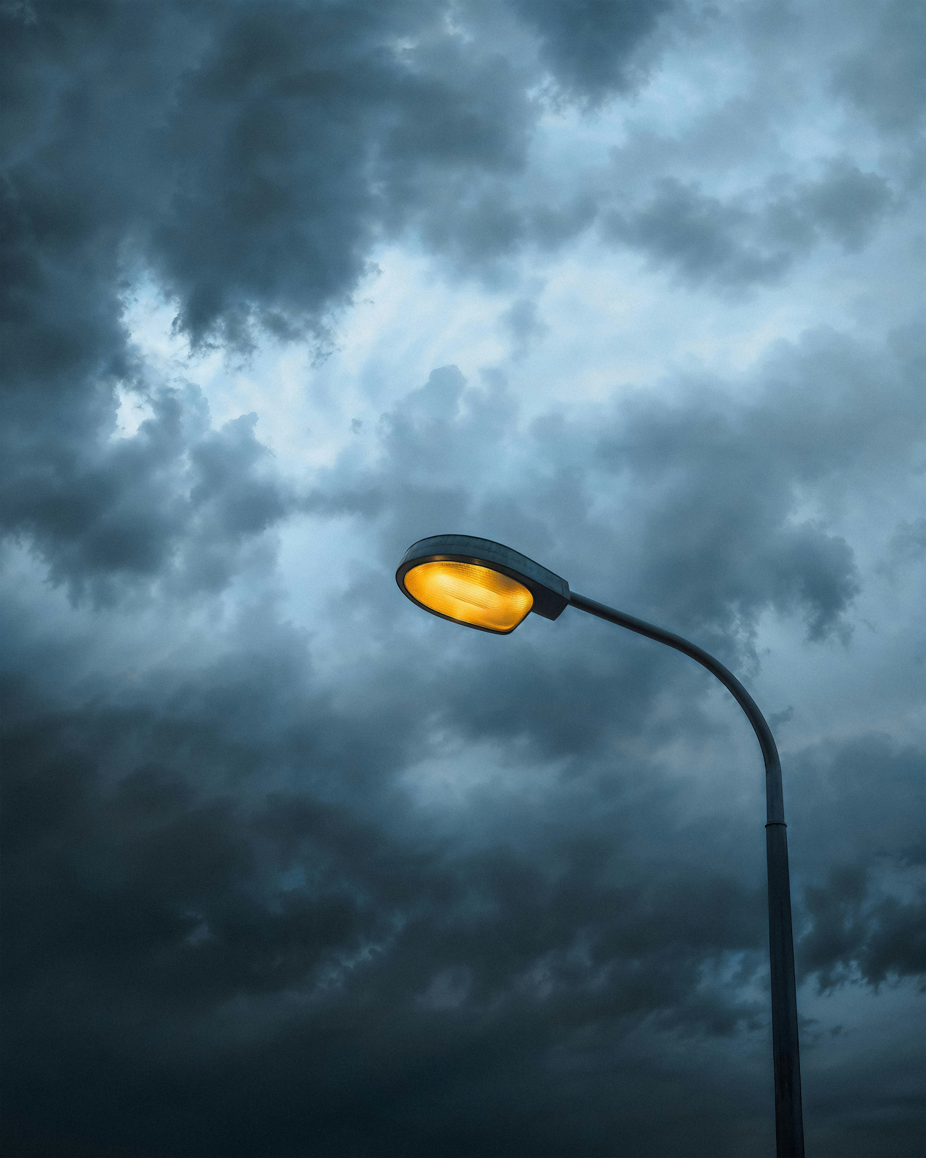A street light with a cloudy sky in the background