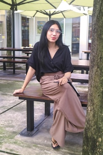 A woman sitting on top of a wooden bench