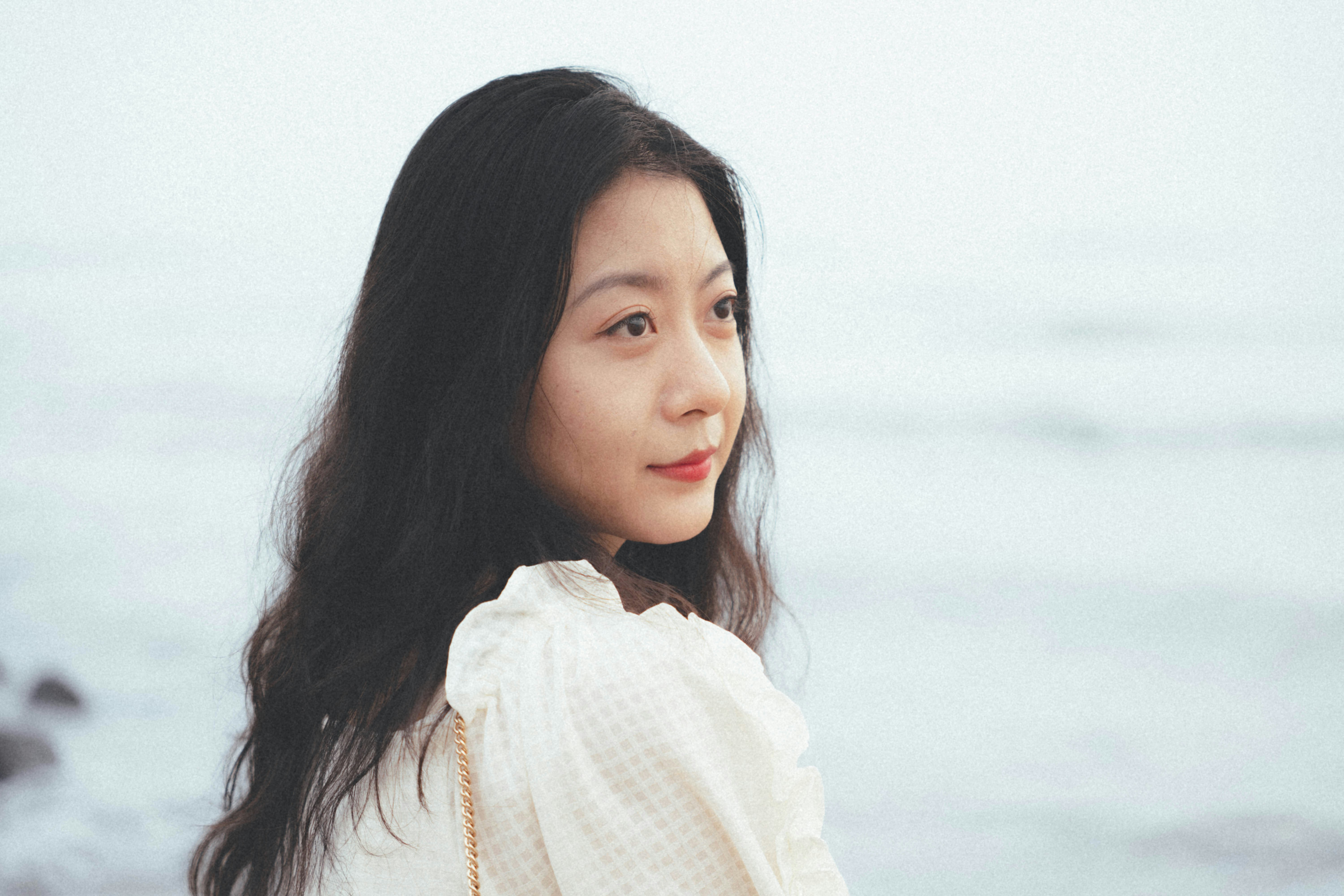 A woman standing on a beach next to the ocean
