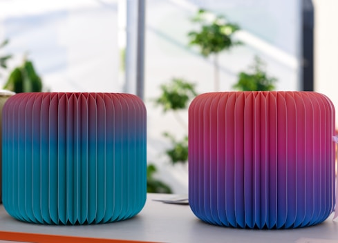 A couple of colorful vases sitting on top of a table