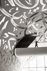 A man walking down a hallway covered in graffiti