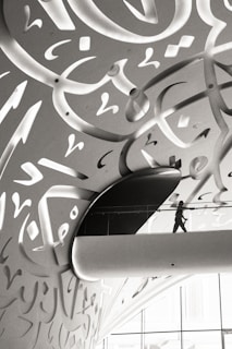 A man walking down a hallway covered in graffiti