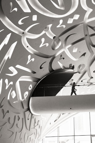 A man walking down a hallway covered in graffiti
