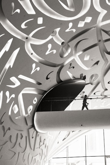A man walking down a hallway covered in graffiti