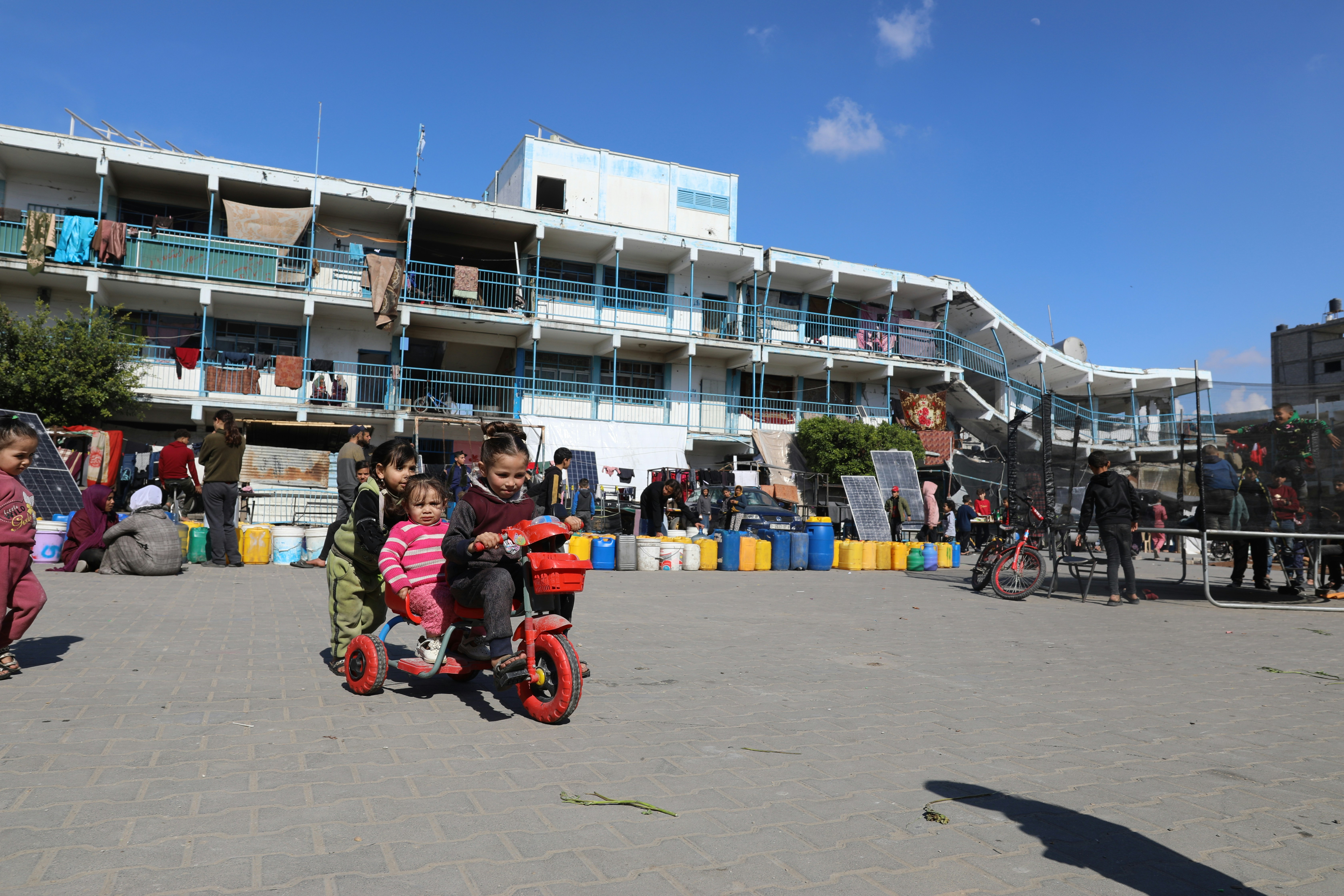 A group of children riding scooters in front of a building