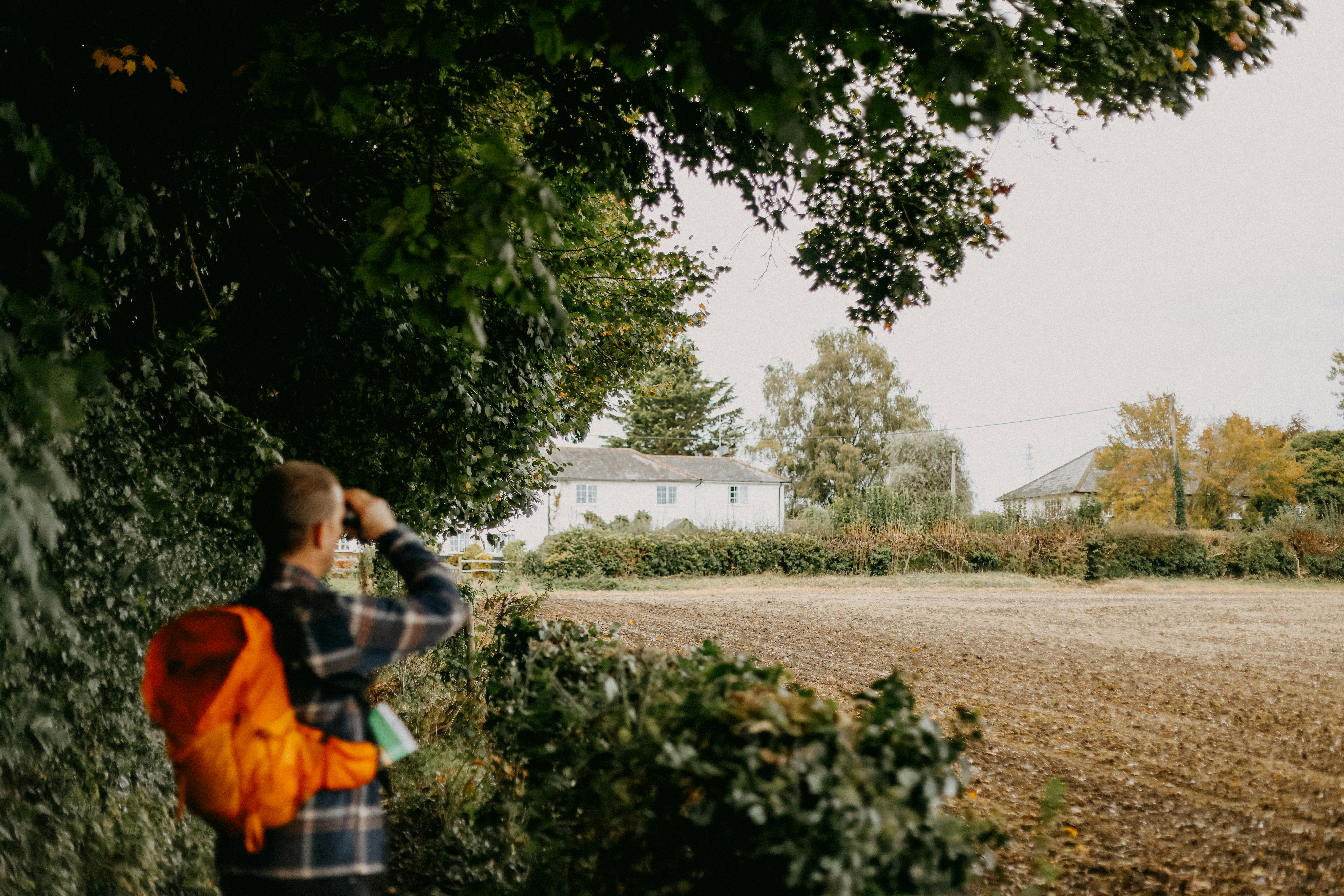 A man standing next to a tall tree