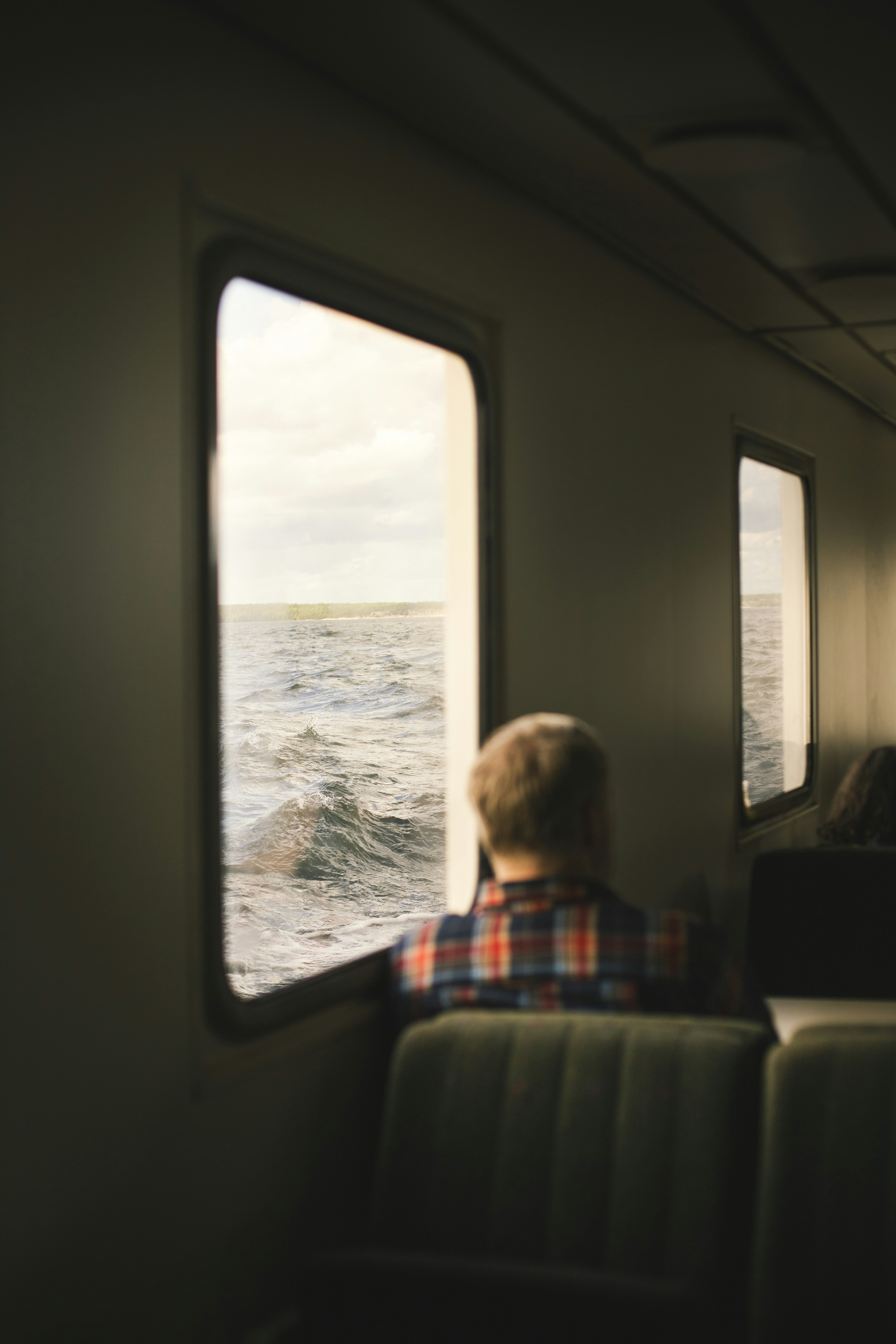 A man sitting on a train looking out the window