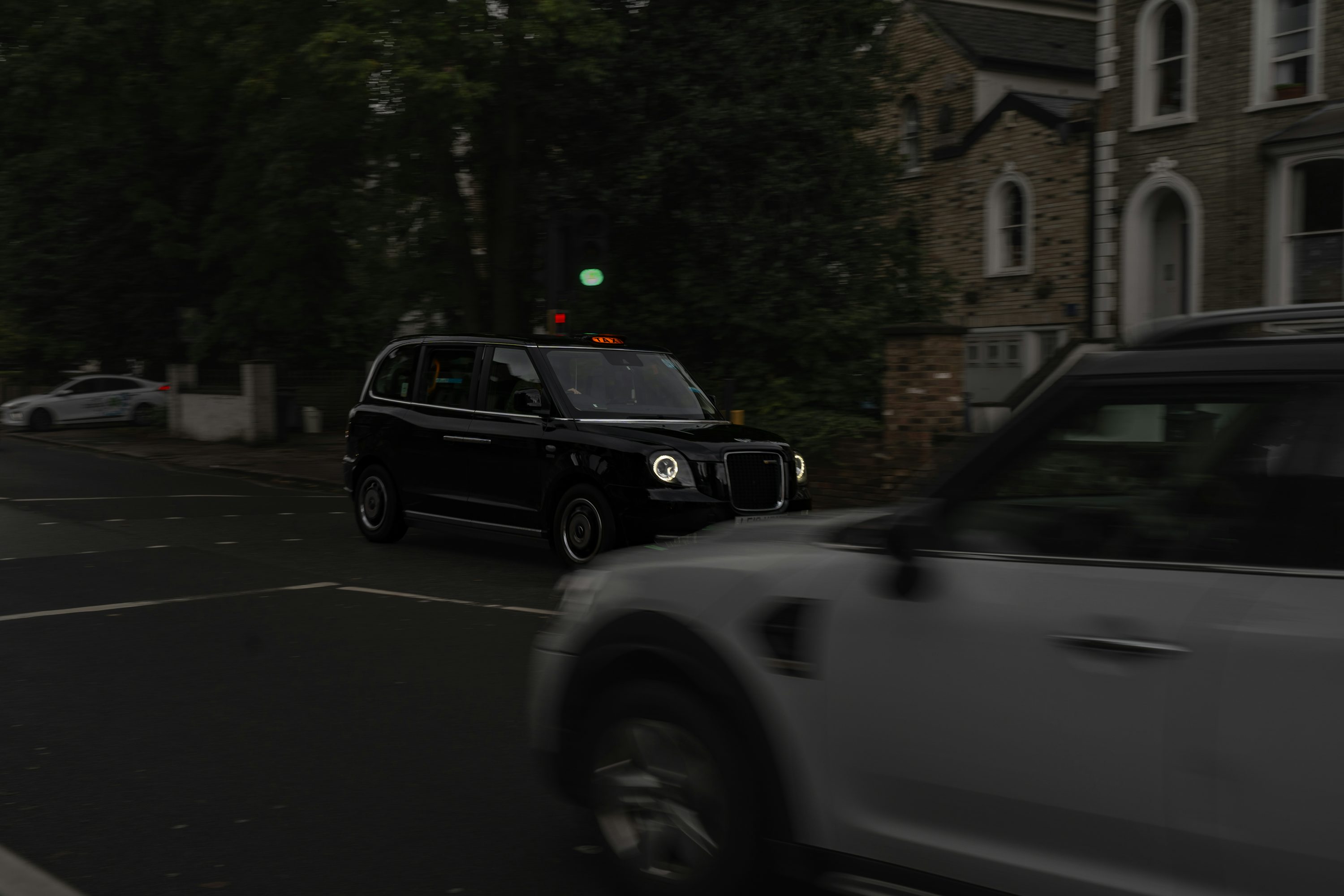 A car driving down a street next to a tall building
