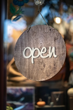 A wooden sign hanging from the side of a window