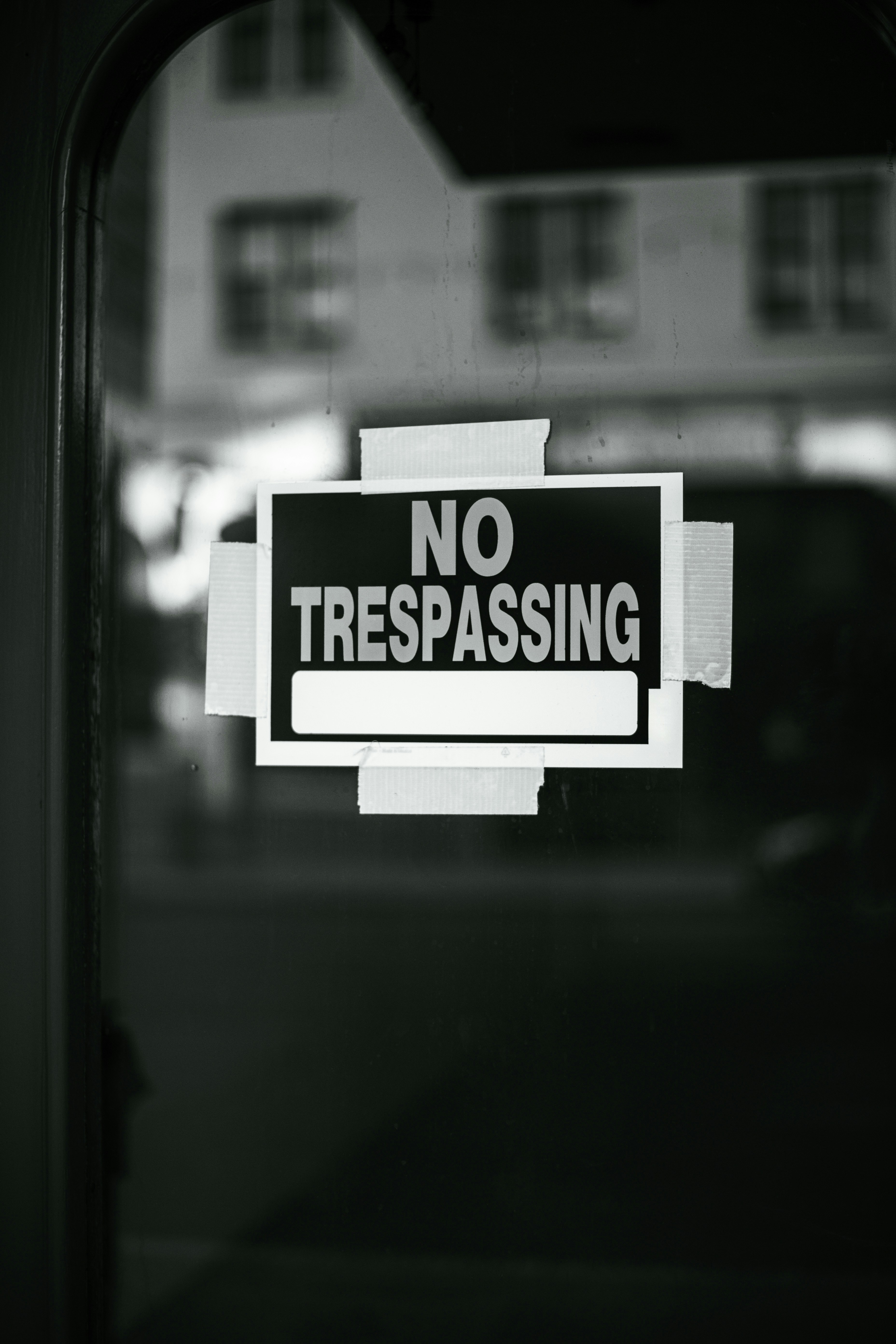 A no trespassing sign is posted on a window