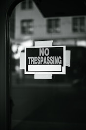 A no trespassing sign is posted on a window