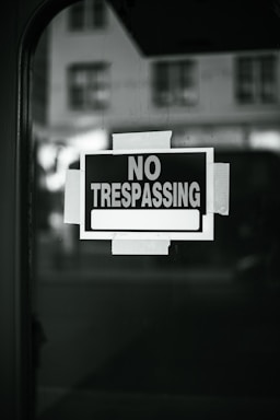 A no trespassing sign is posted on a window
