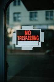 A no trespassing sign is posted on a window