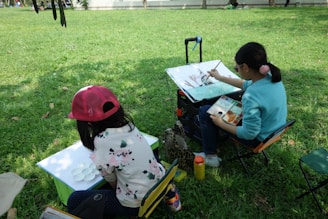 A couple of kids that are sitting in the grass