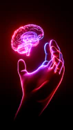 A person's hand holding a glowing brain model