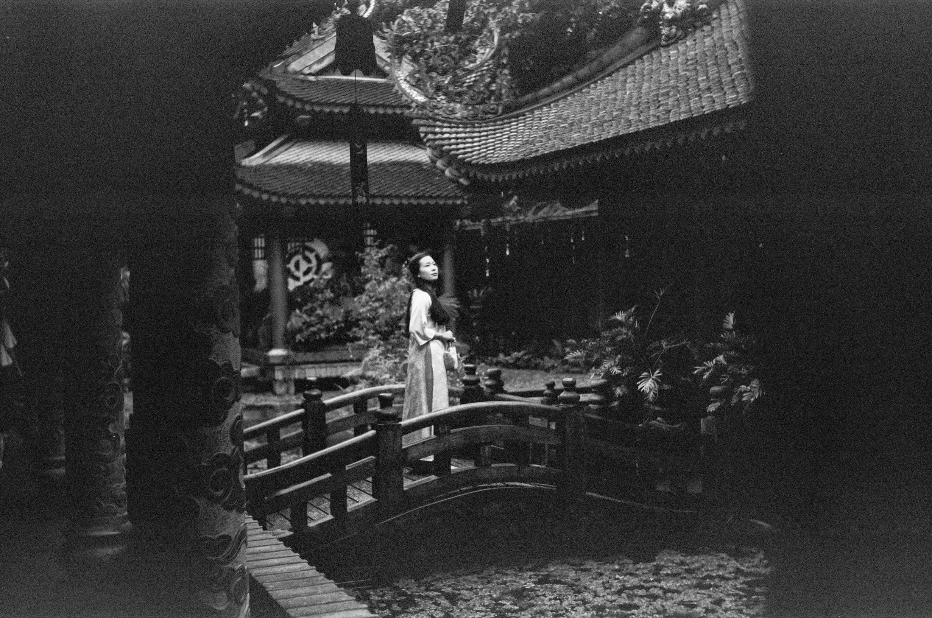 A woman standing on a bridge in front of a building