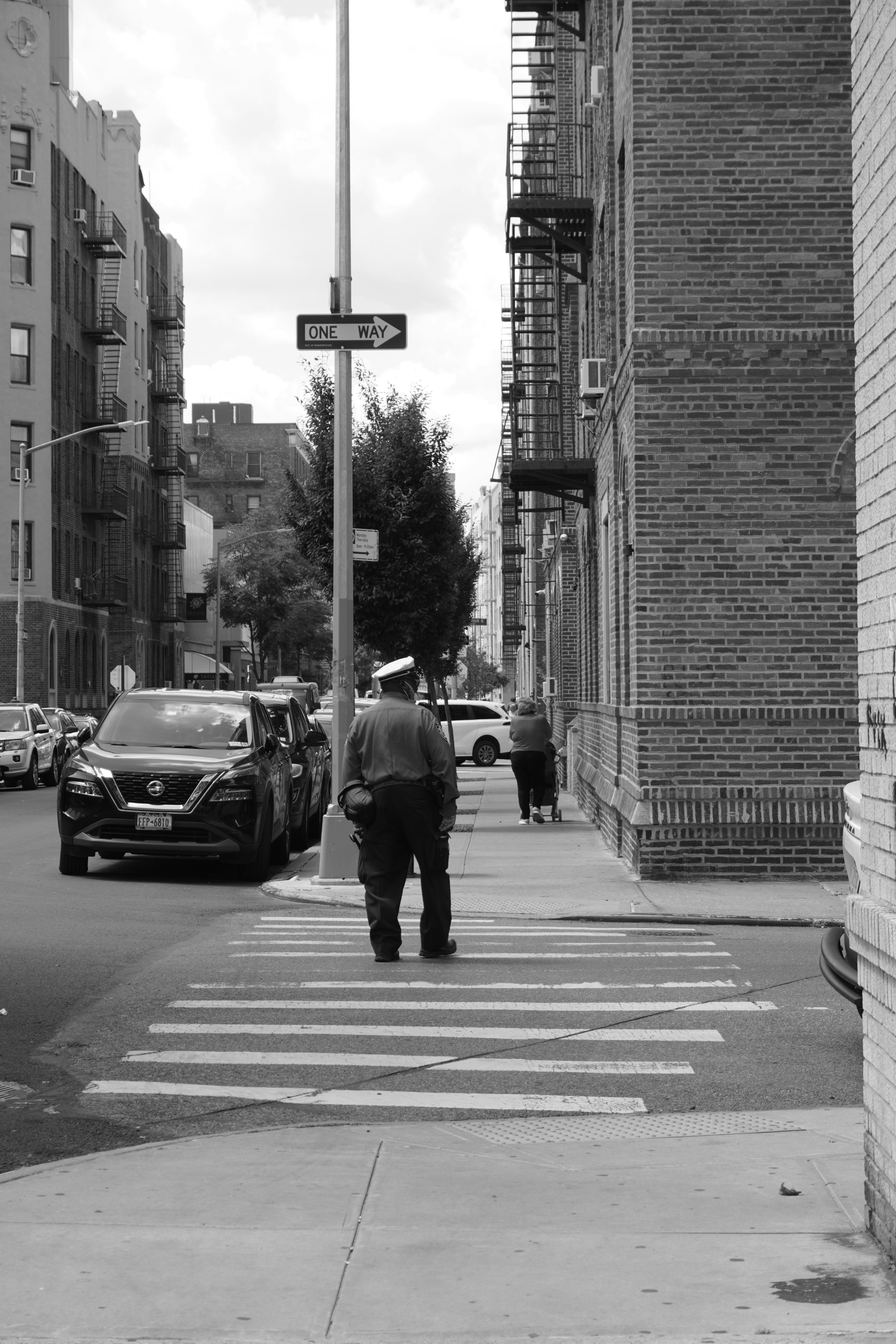 Una foto in bianco e nero di un uomo che cammina per strada
