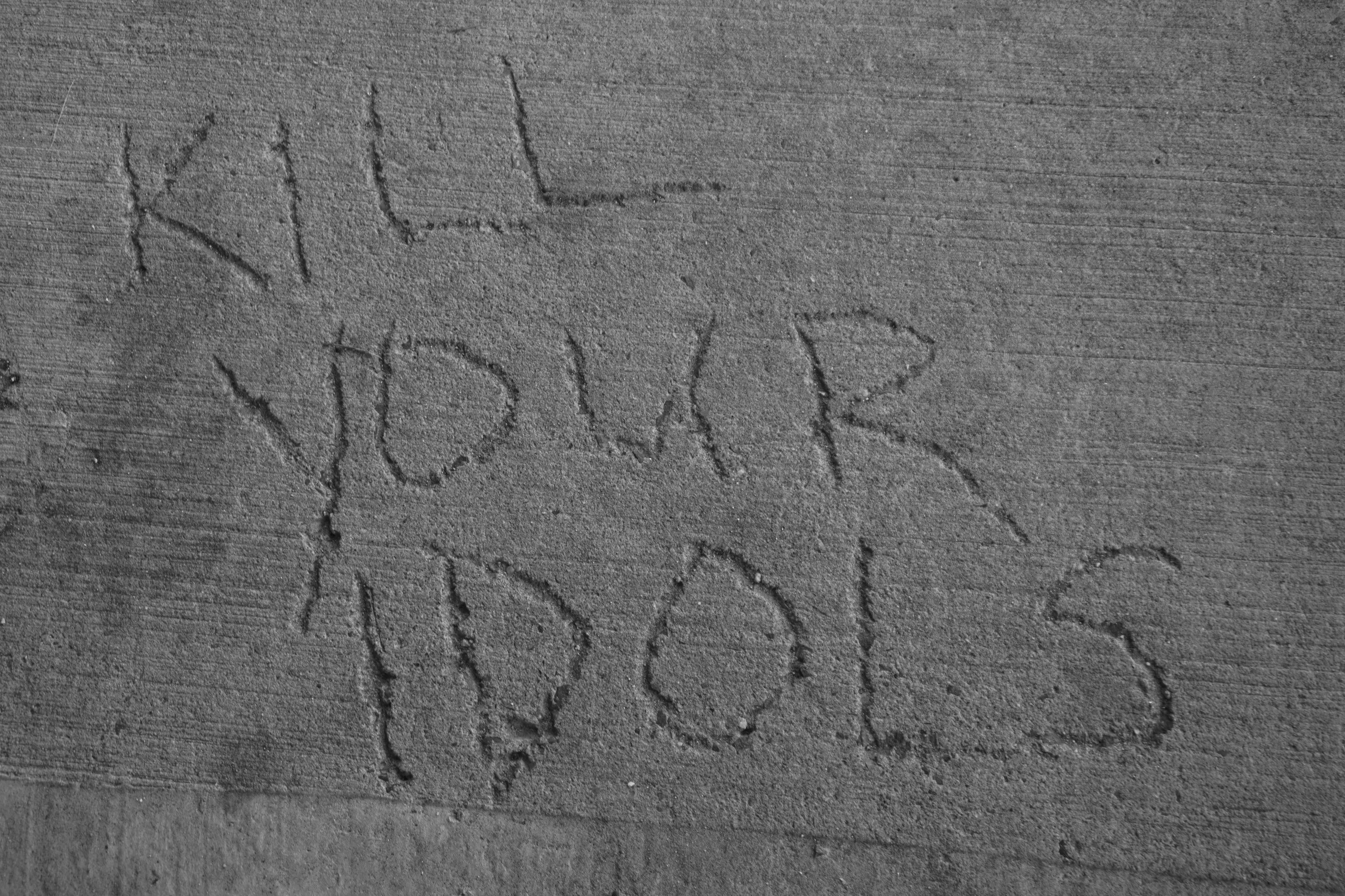 A black and white photo of a person writing on a wall