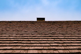 The roof of a building with a sky in the background that has been shingled