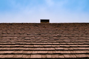 The roof of a building with a sky in the background