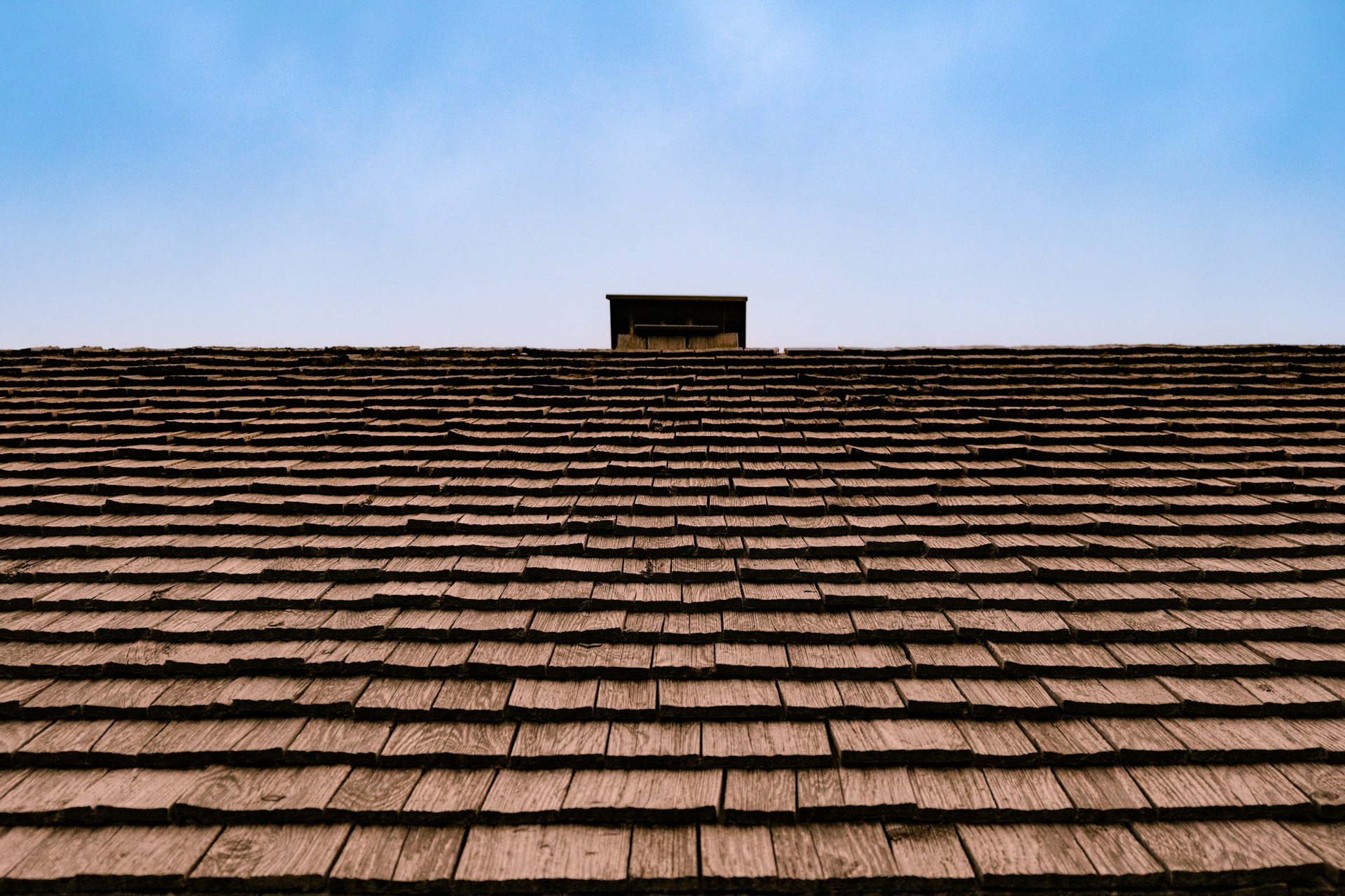 The roof of a building with a sky in the background