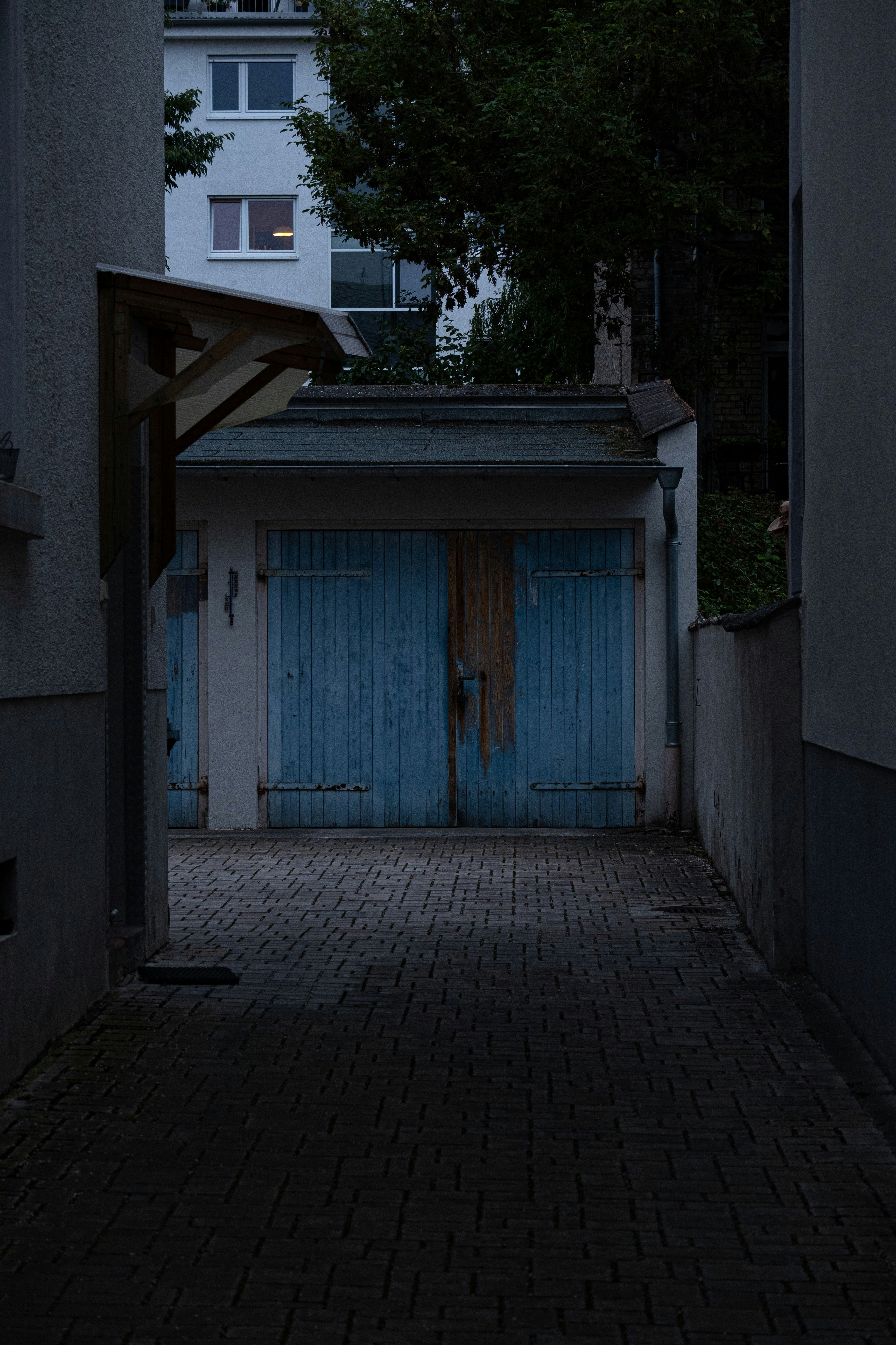 Eine dunkle Gasse mit blauer Tür
