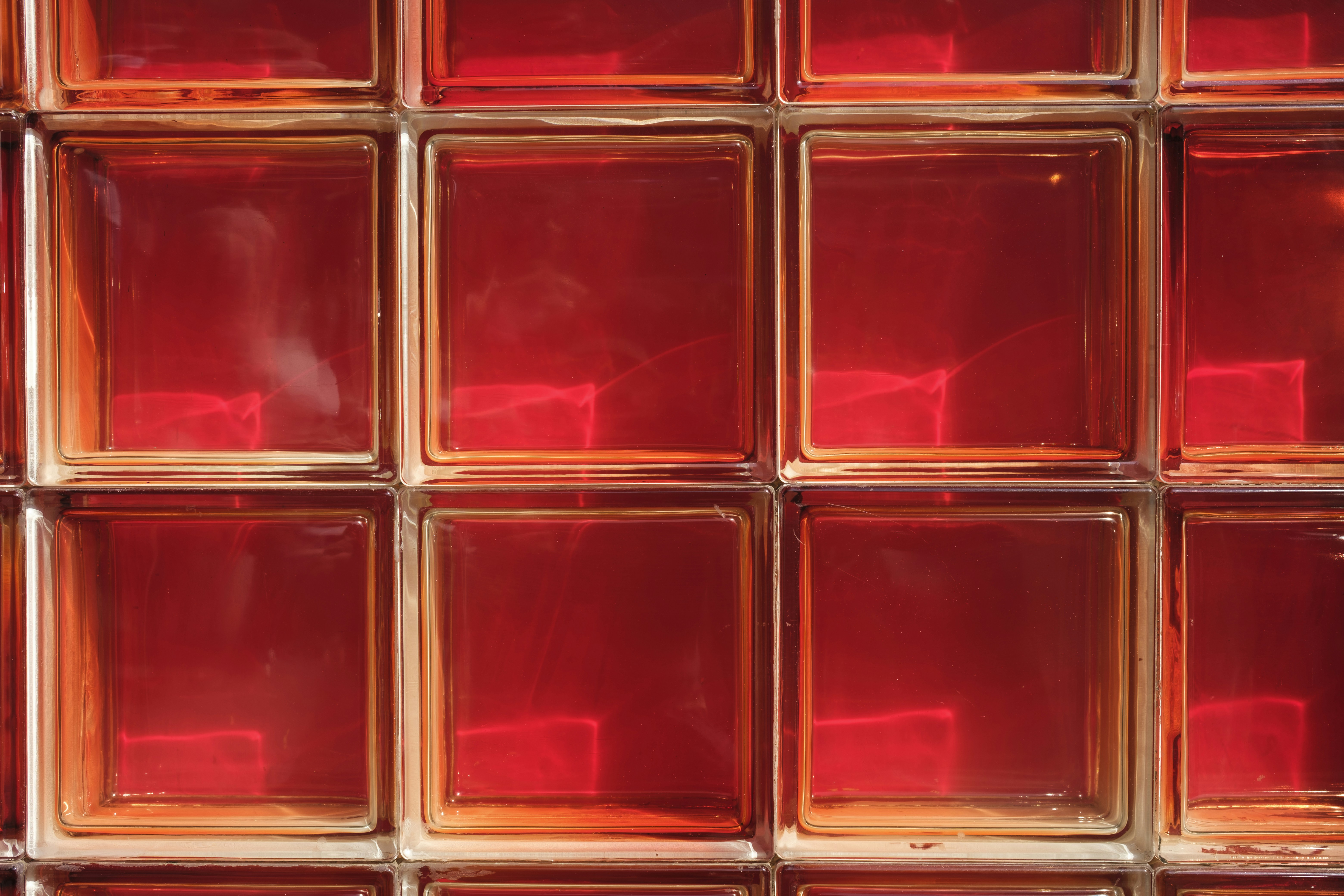 A close up of a red glass block wall