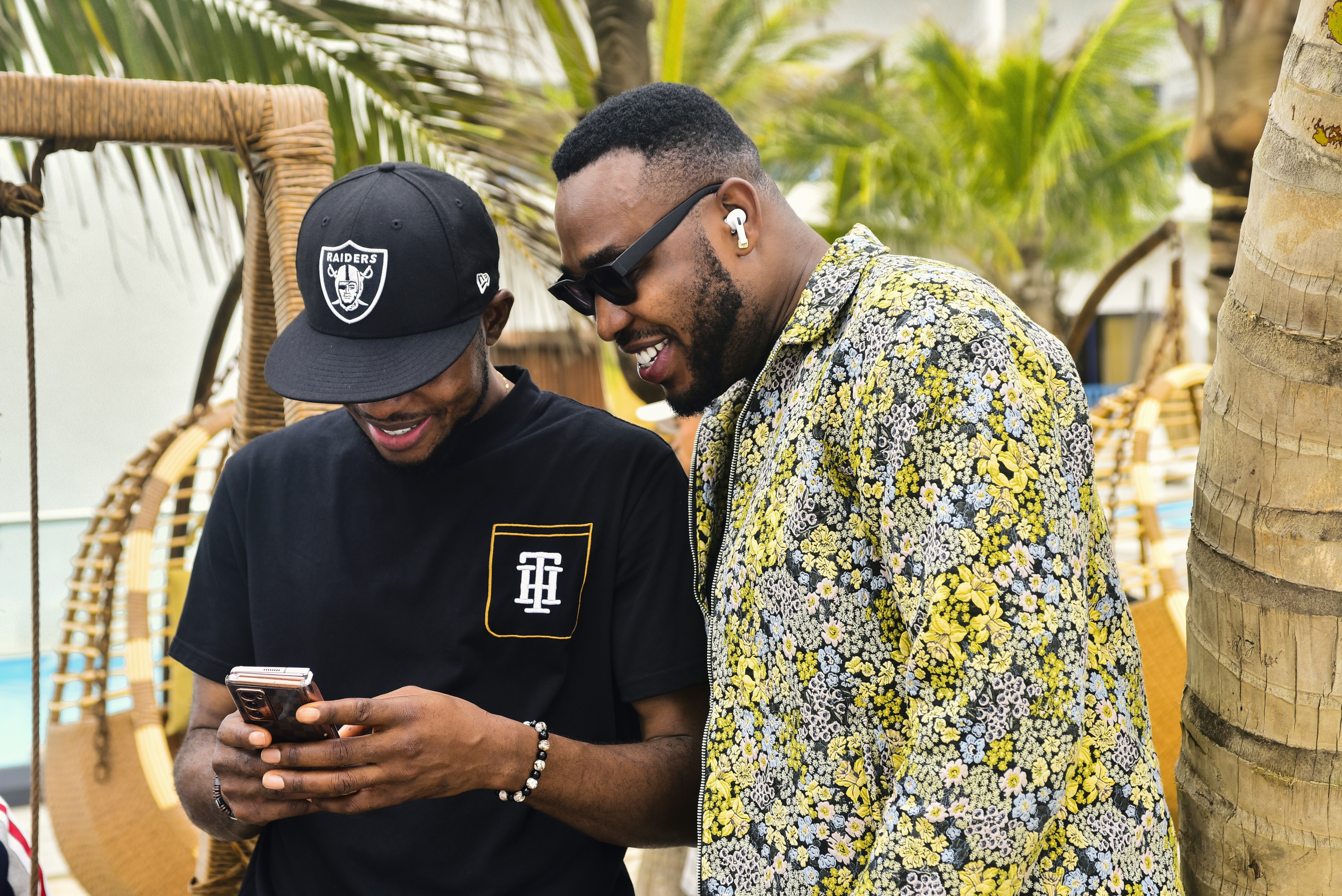 A young Nigerian woman in Lagos smiling as she looks at a savings notification on her smartphone.