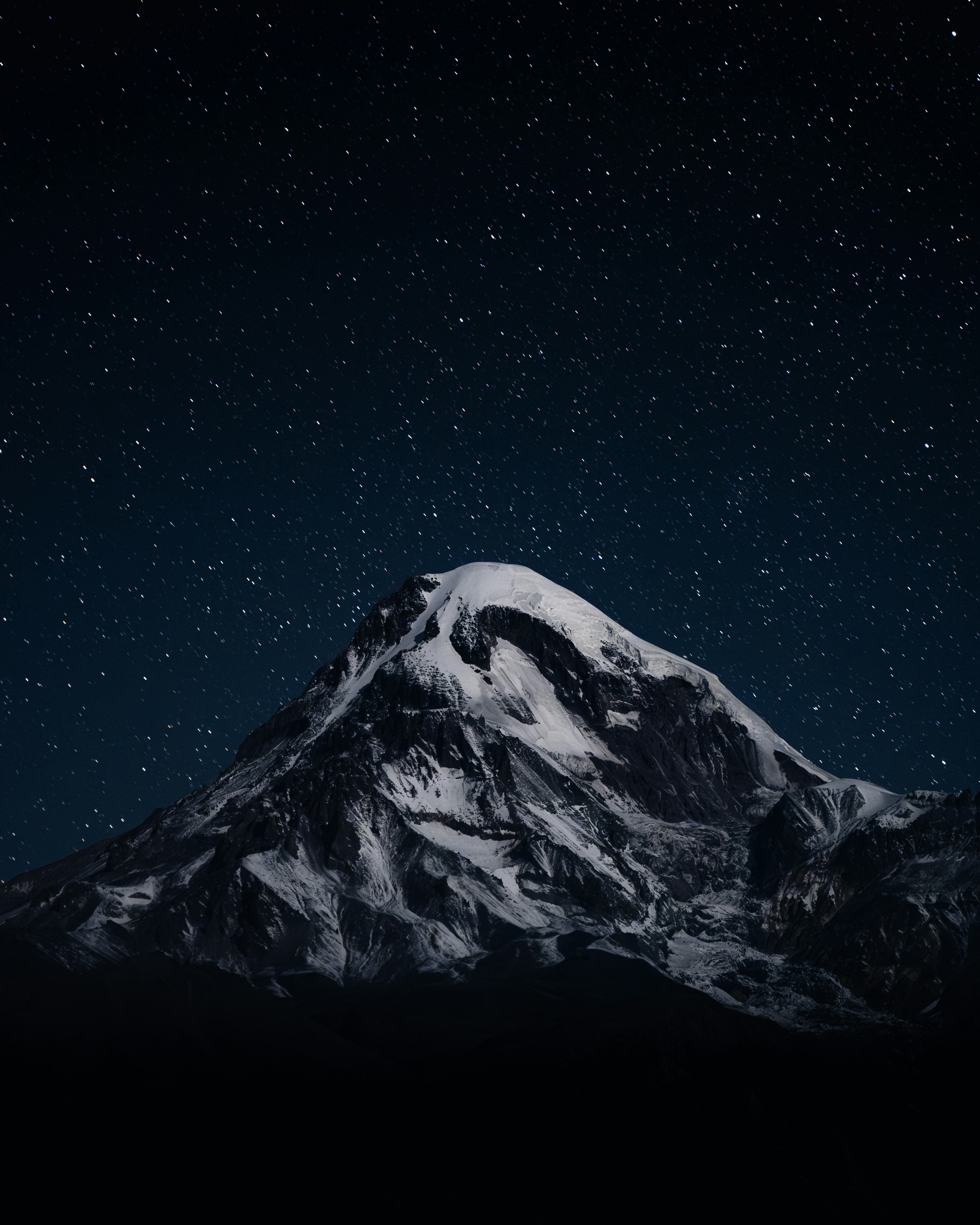 Mood image: a snow covered mountain under a starry night sky