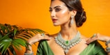 A woman in a green dress with a necklace and earrings