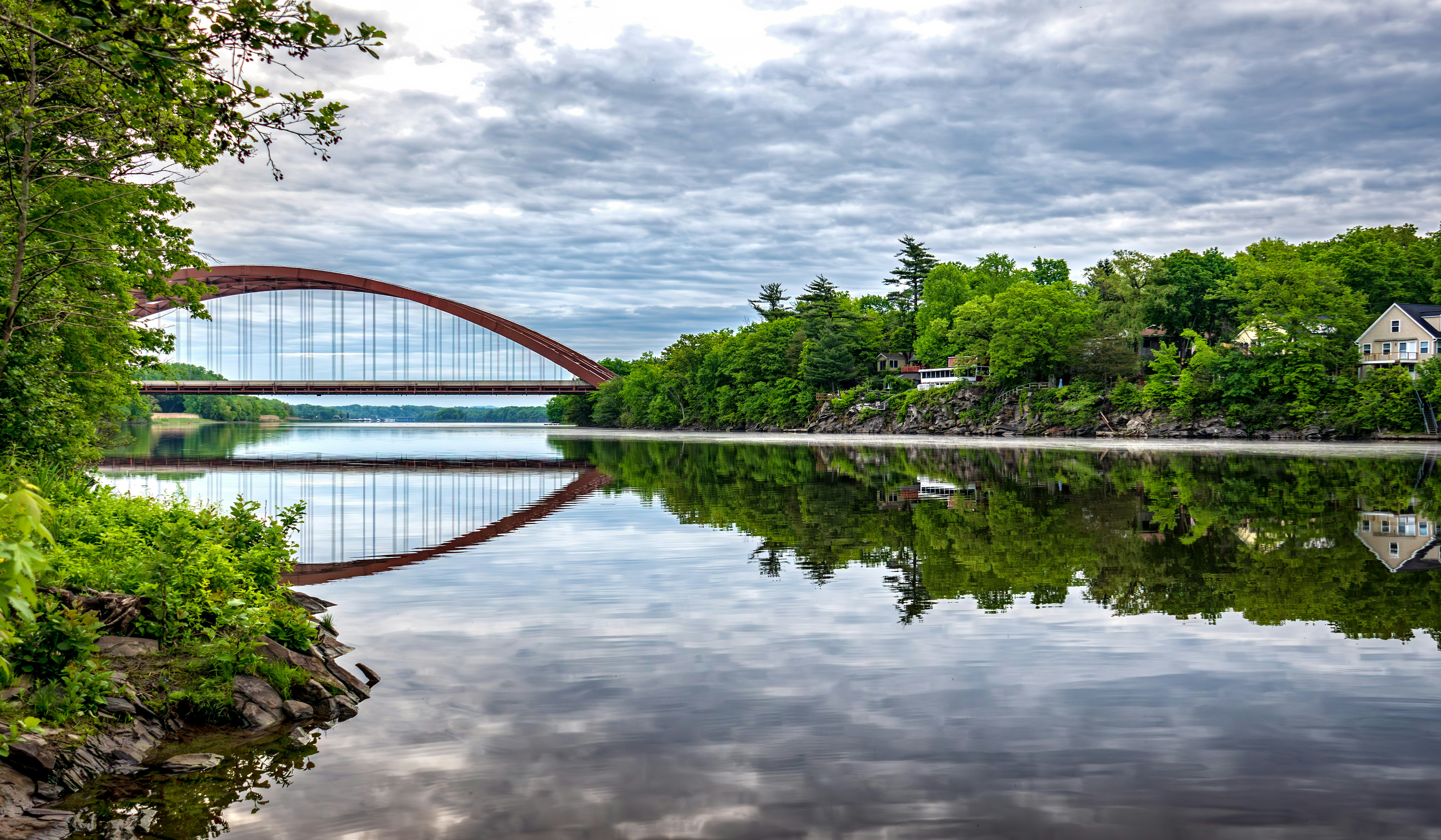 A bridge over a body of water surrounded by trees