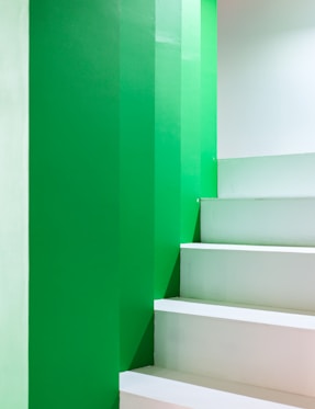 A white staircase with green walls and white steps