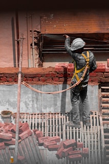 A construction worker working on a brick wall