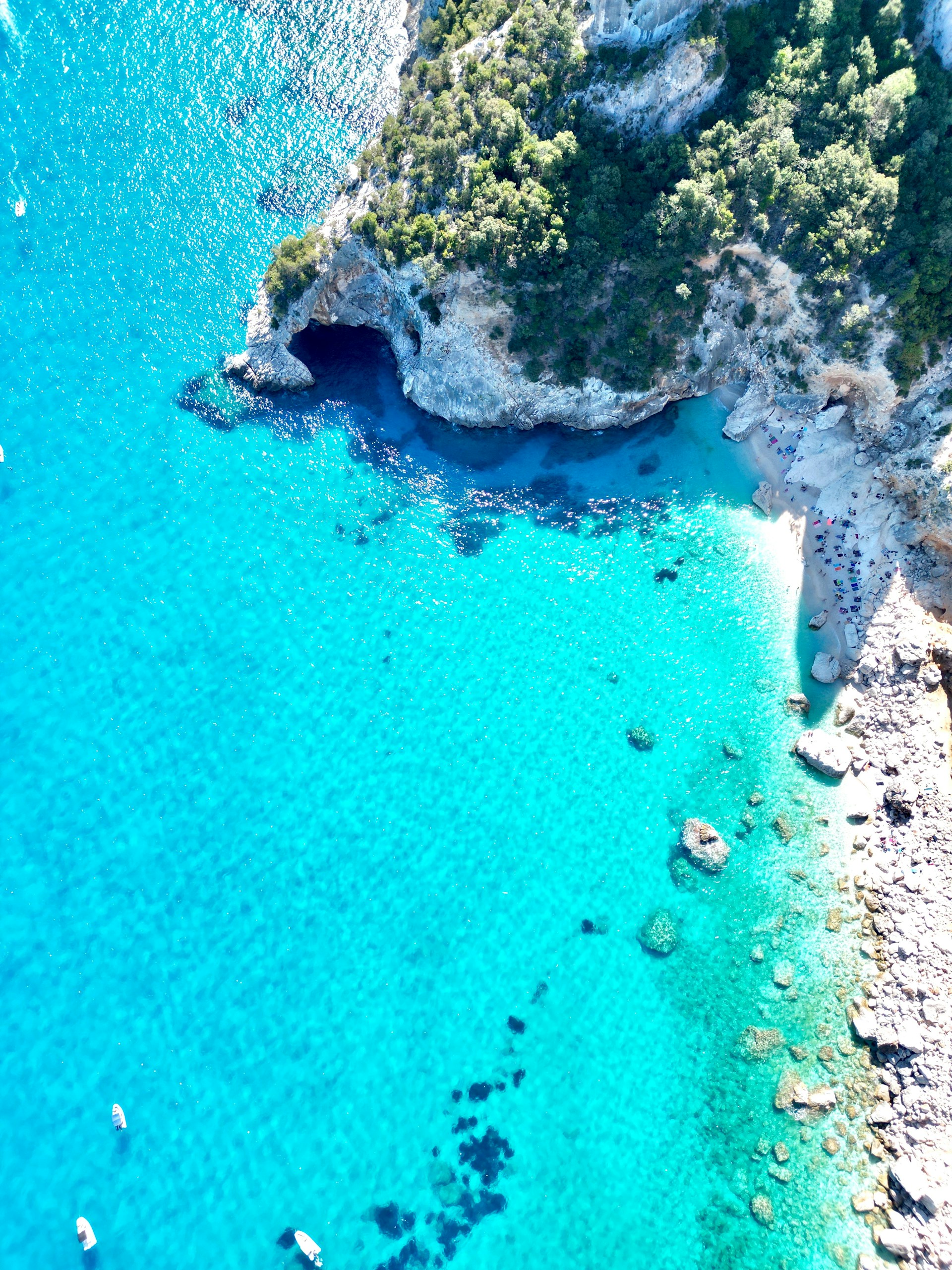 A bird's eye view of a beach with a boat in the water