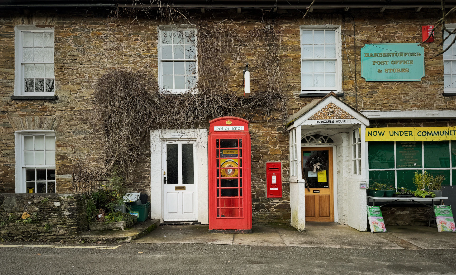 A red phone booth in front of a brick building
