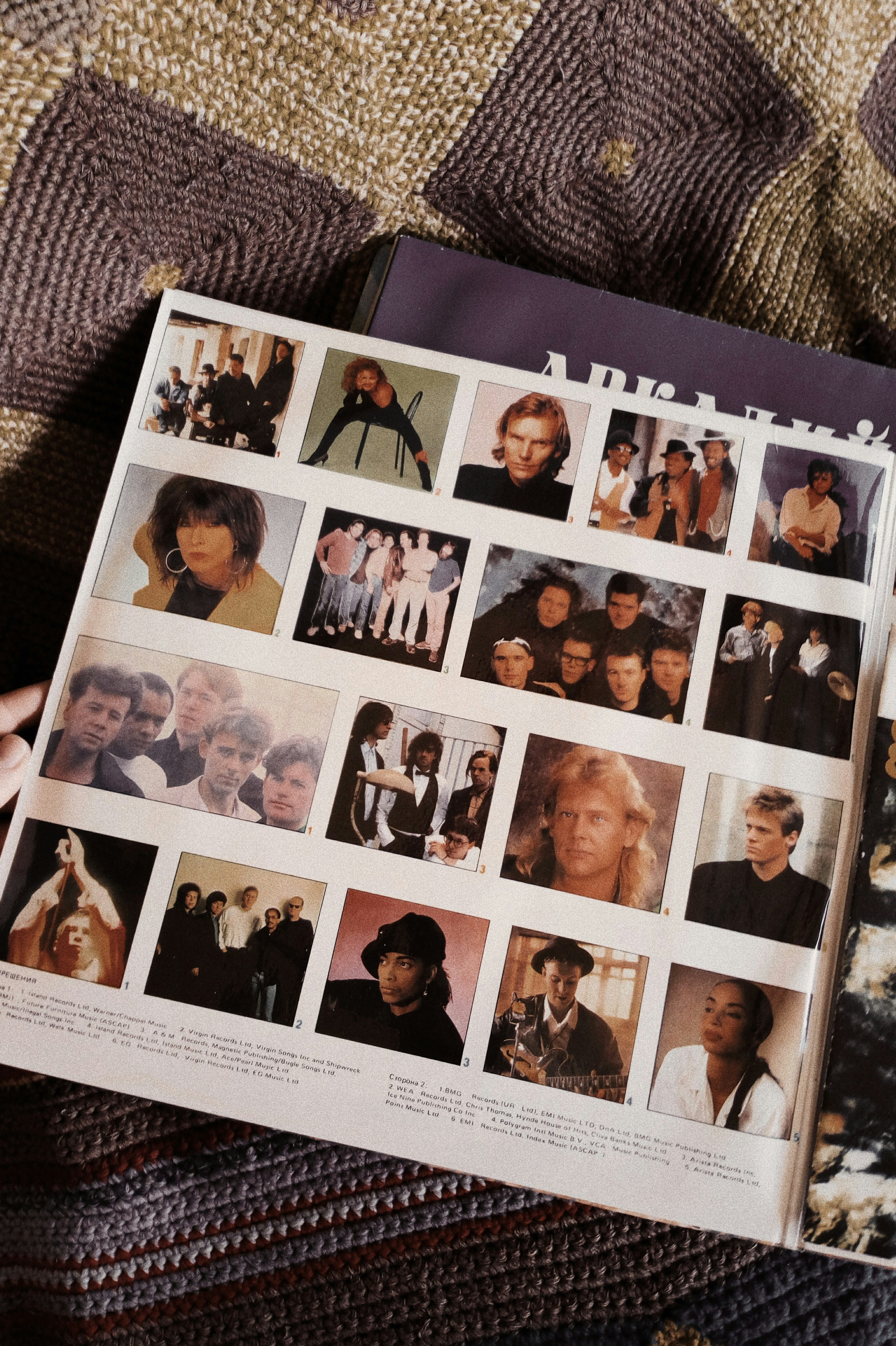 A person holding a book with pictures of people on it