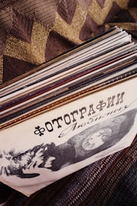 A stack of records sitting on top of a bed