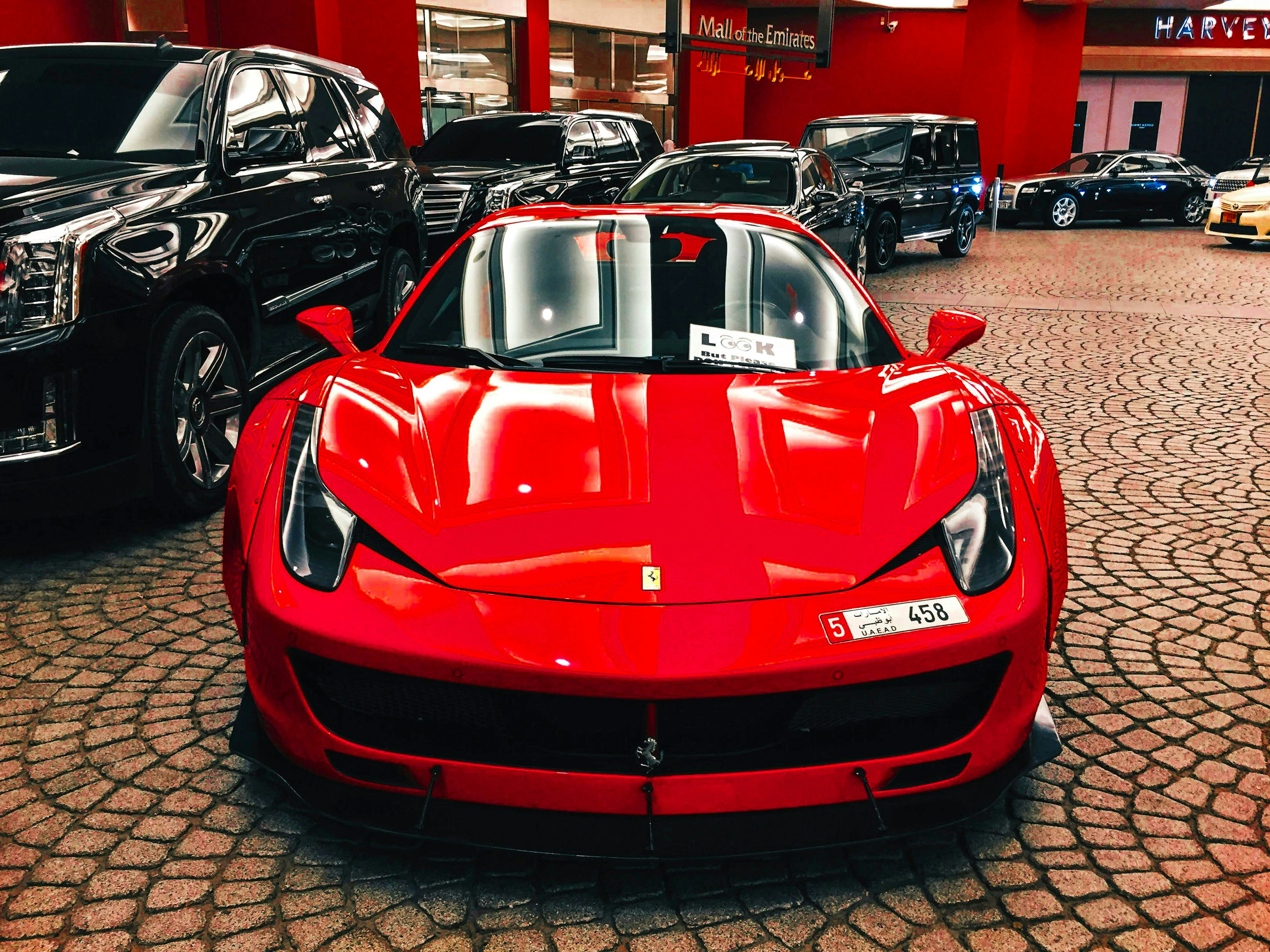 A red sports car is parked in a showroom