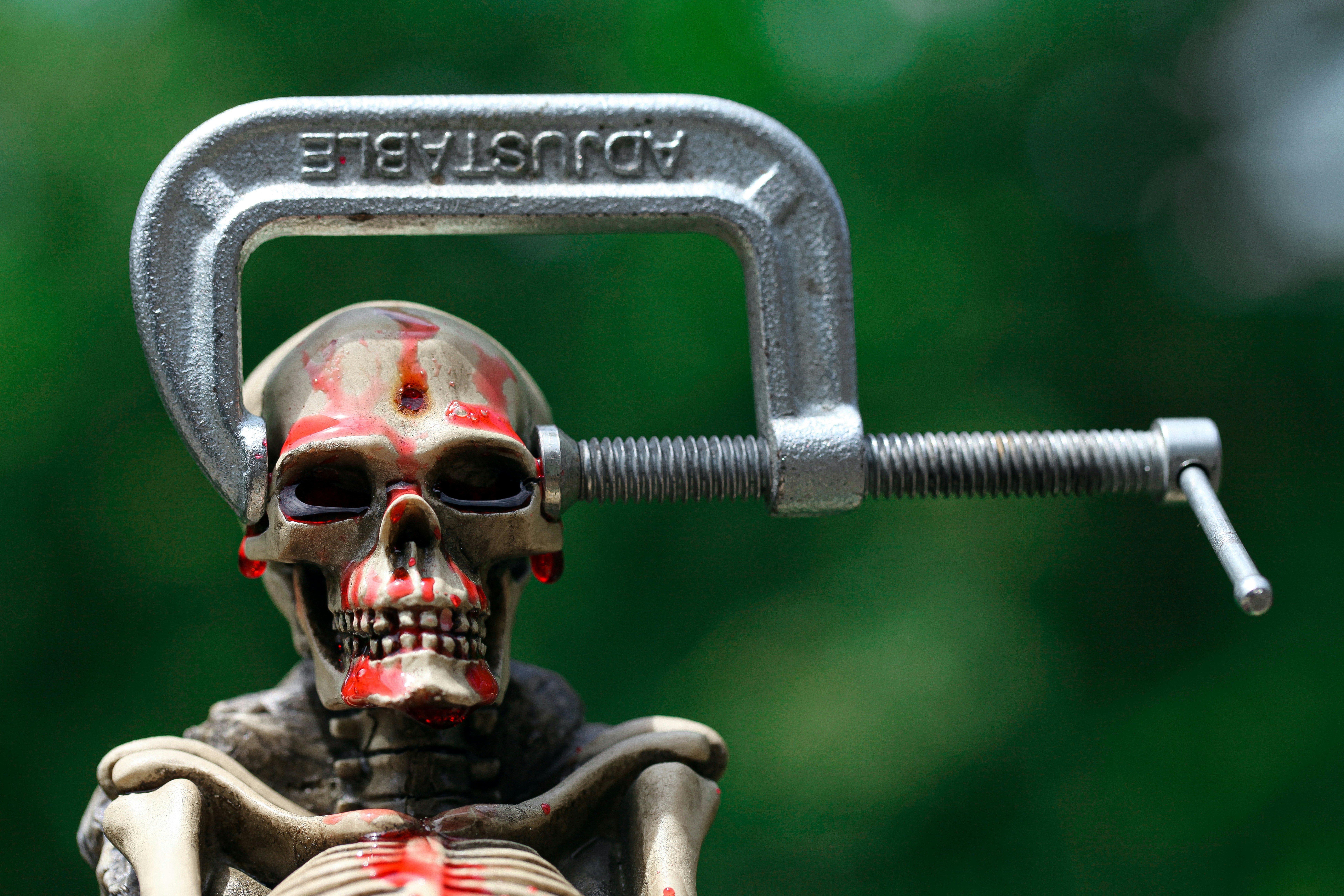 A toy skeleton holding a metal object with blood on it