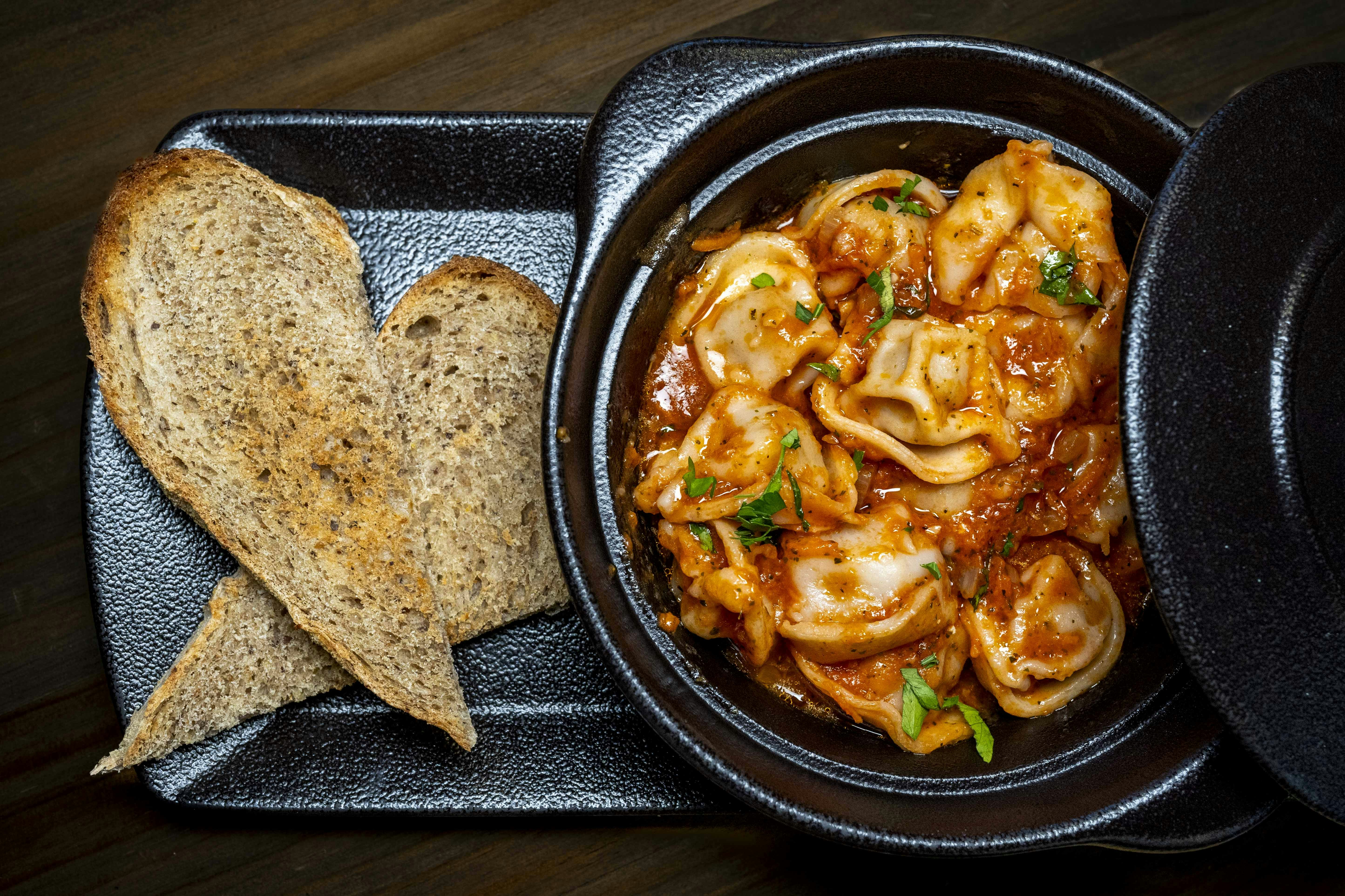 A bowl of pasta and bread on a table