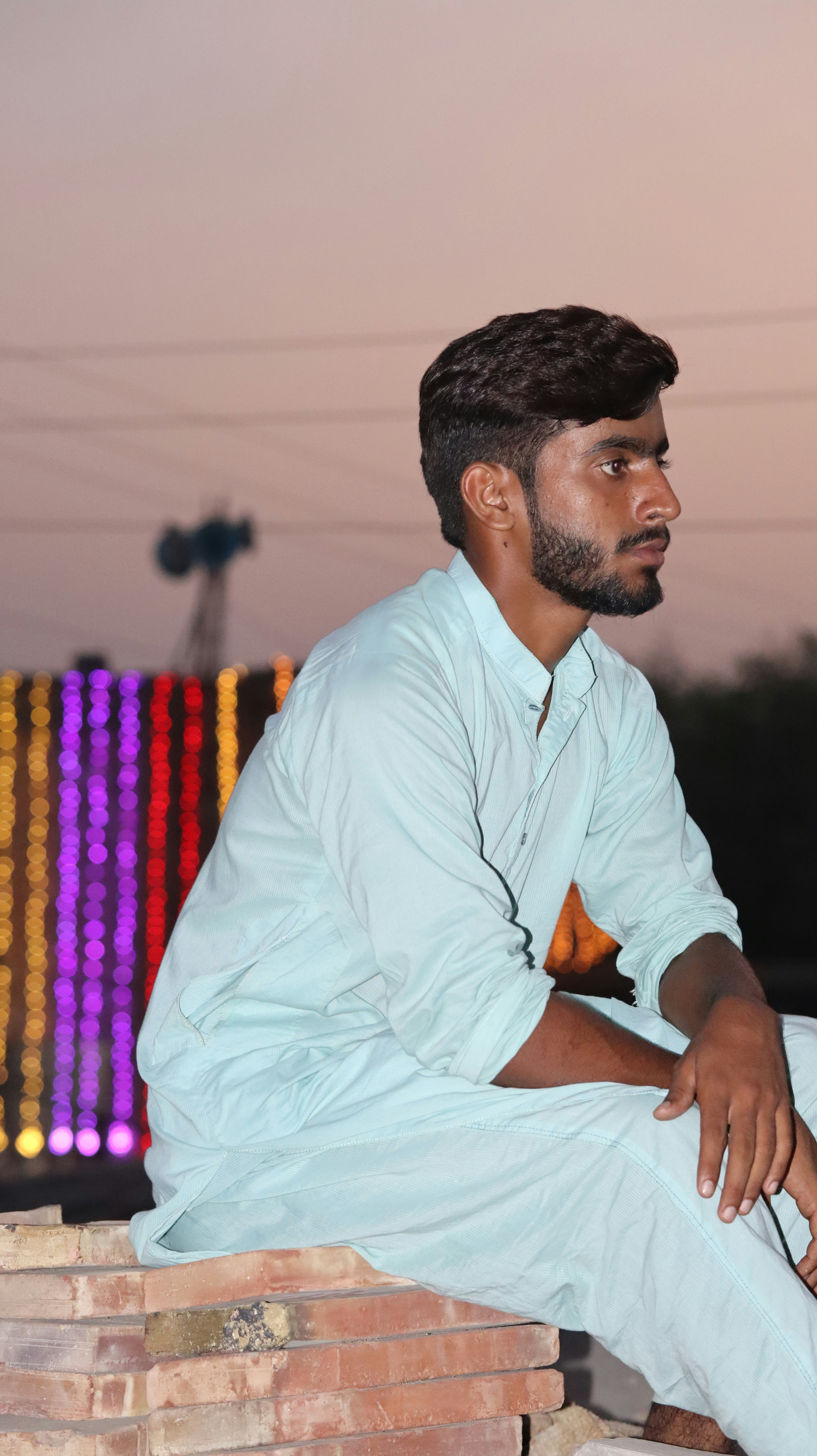 A man sitting on top of a pile of bricks