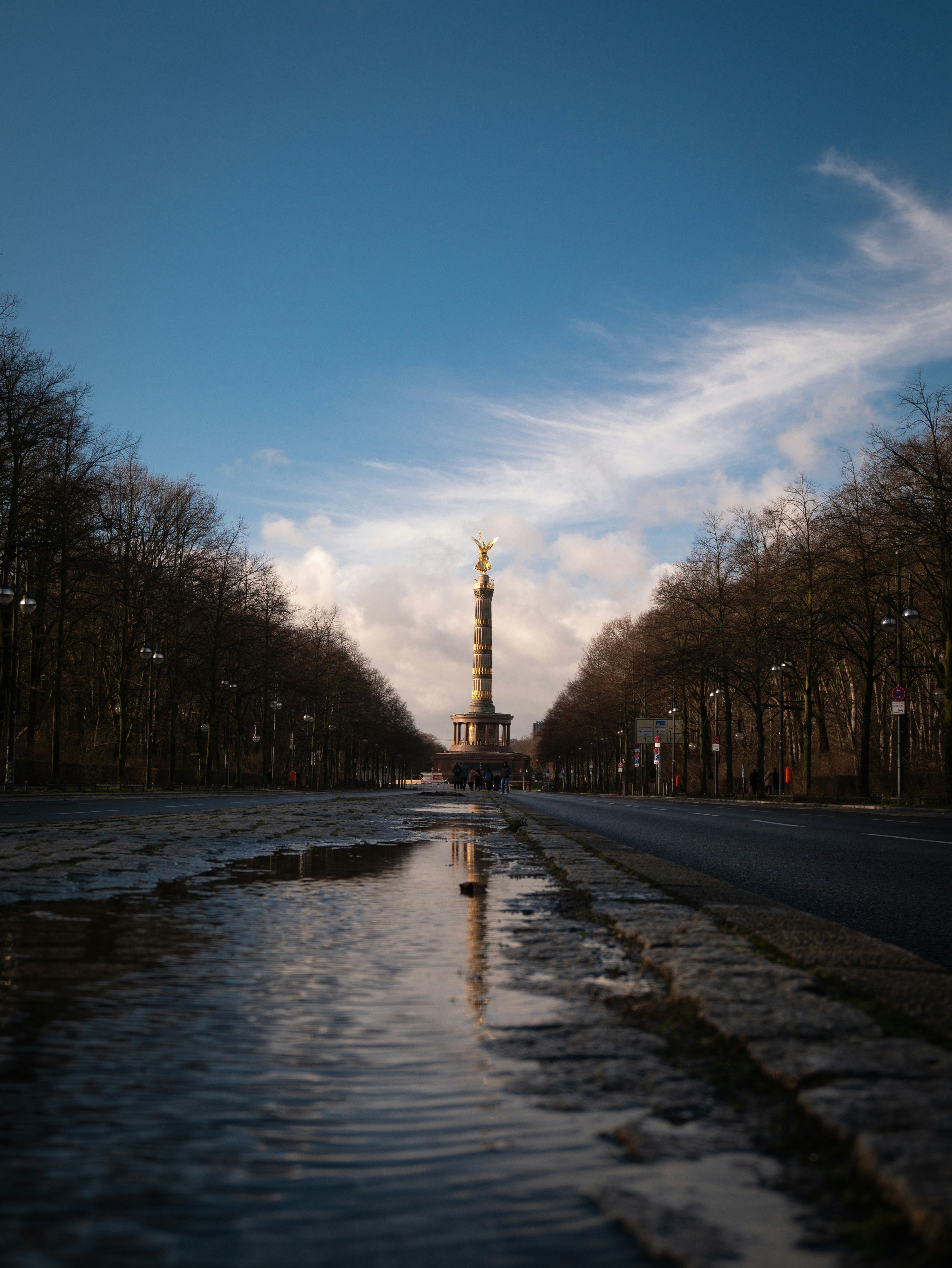 A river running through a park next to a tall tower