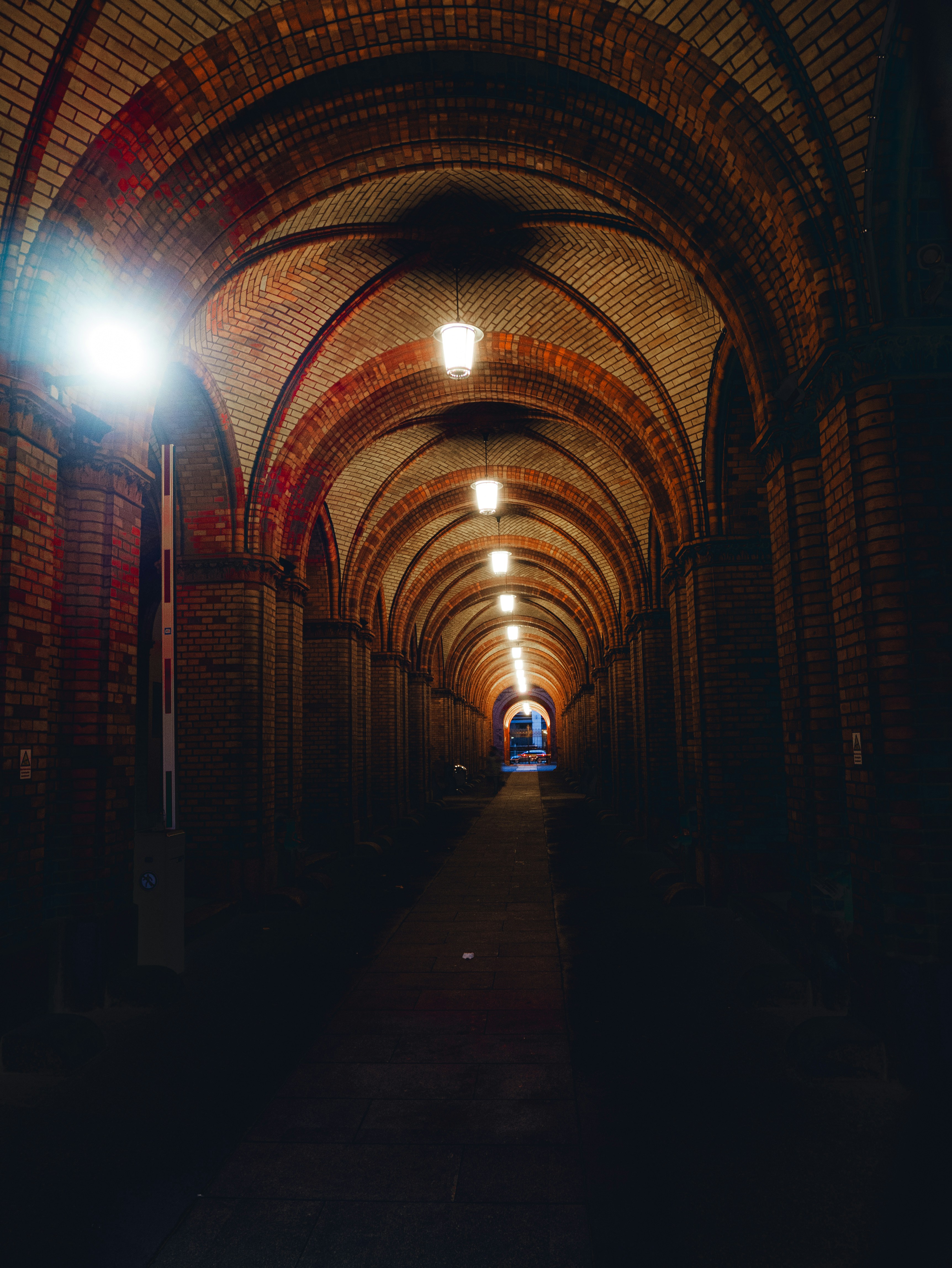 A long brick tunnel with a light at the end